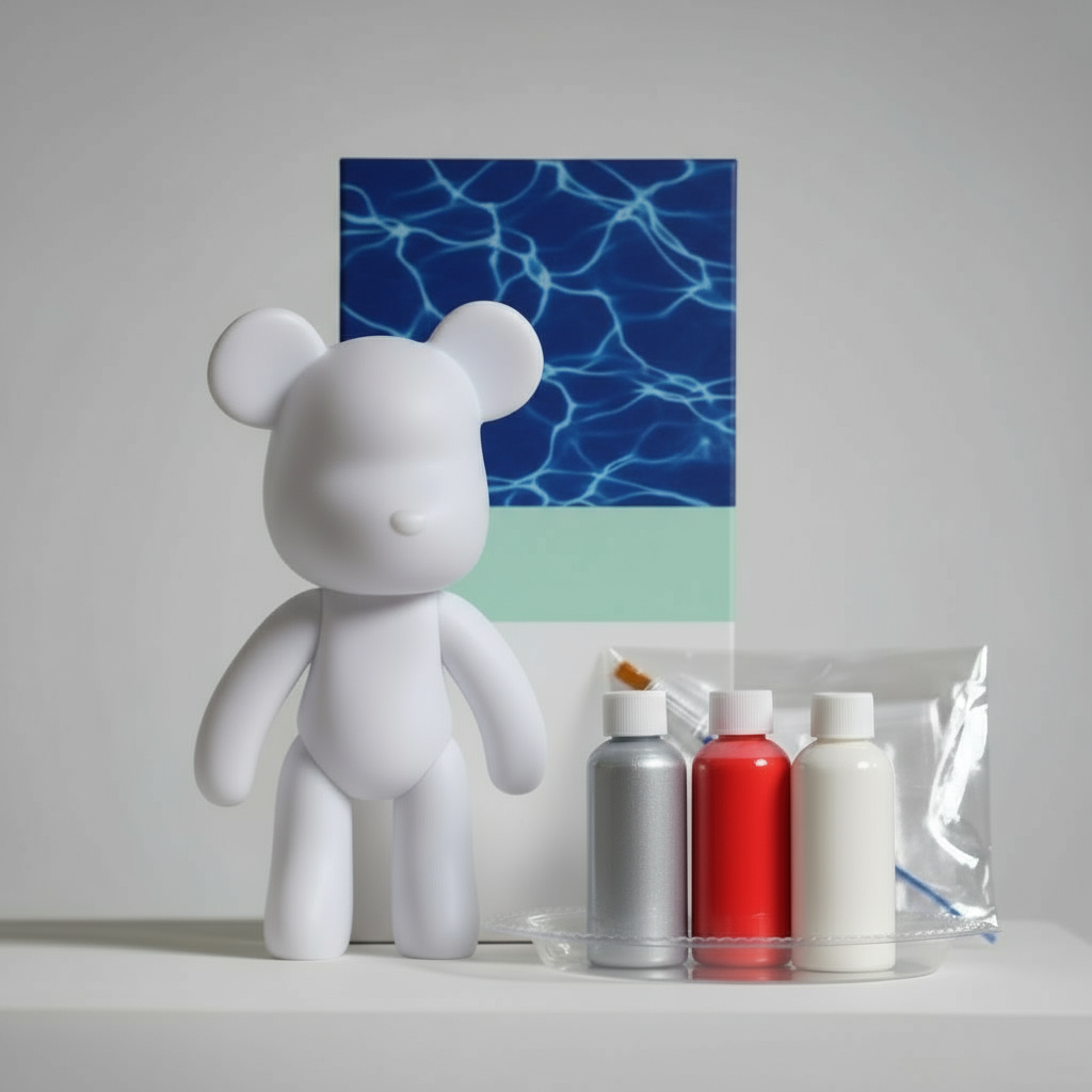 White bear figure next to art supplies on a gray surface with a box in the background.